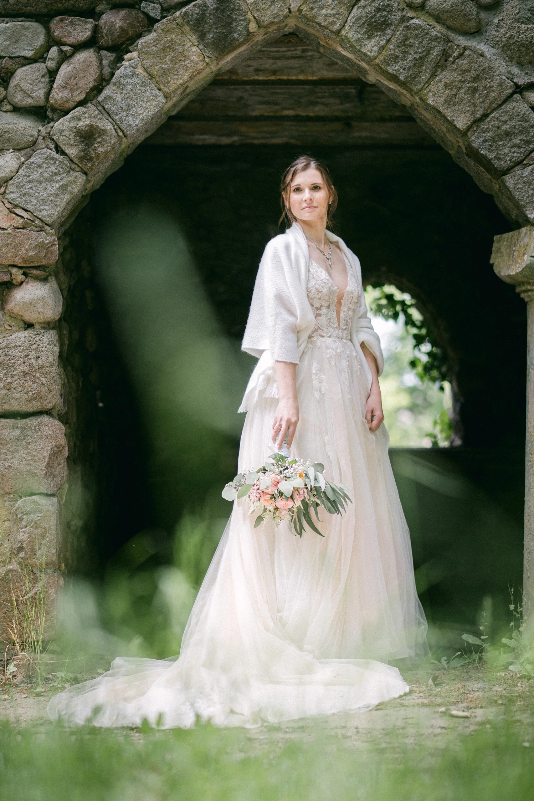 Bride in a stone archway of a castle chapel