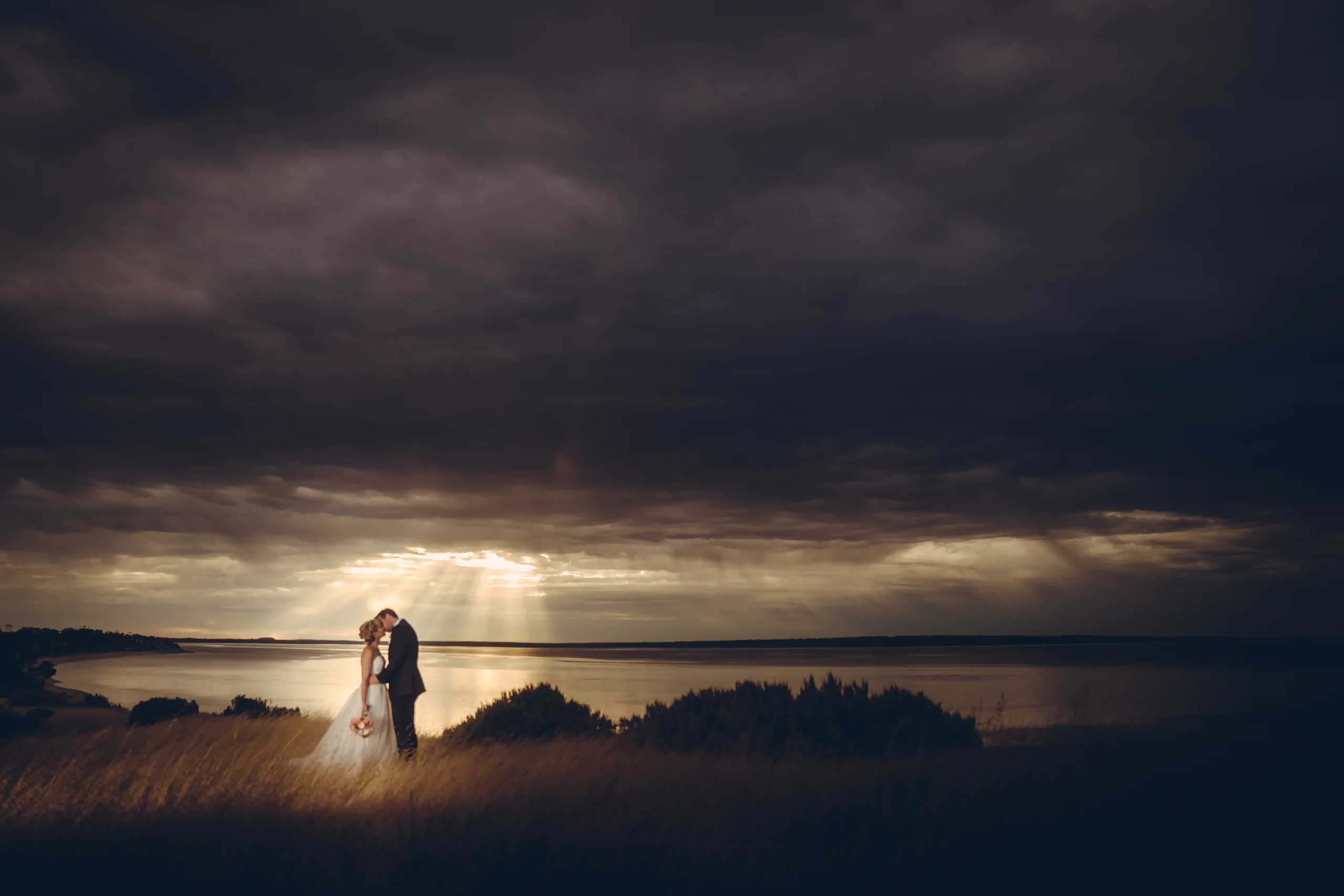 Eloping couple alone in a vast sunset landscape