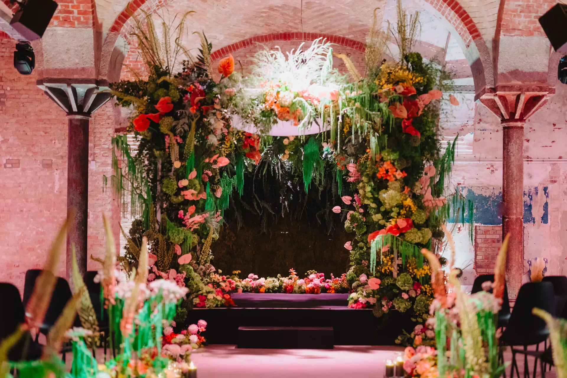 Floral chuppah installation at DEEP Berlin, lit in pink